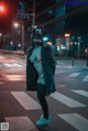 A woman in a cat mask is standing in the middle of the street.