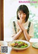 A woman sitting at a table with a plate of food.