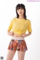 a woman in a yellow shirt and a colorful skirt