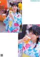 A woman in a kimono holding a cup of orange juice.