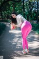 A woman in pink leggings looking at her cell phone.