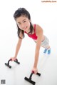 A young woman doing push ups on a white floor.